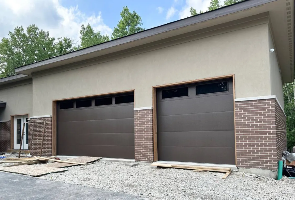 Brown garage door on brick home — annual maintenance extends the life of every component