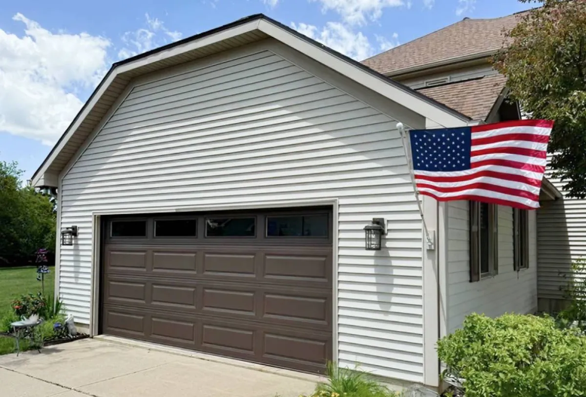 Well-maintained brown raised panel garage door on a residential home
