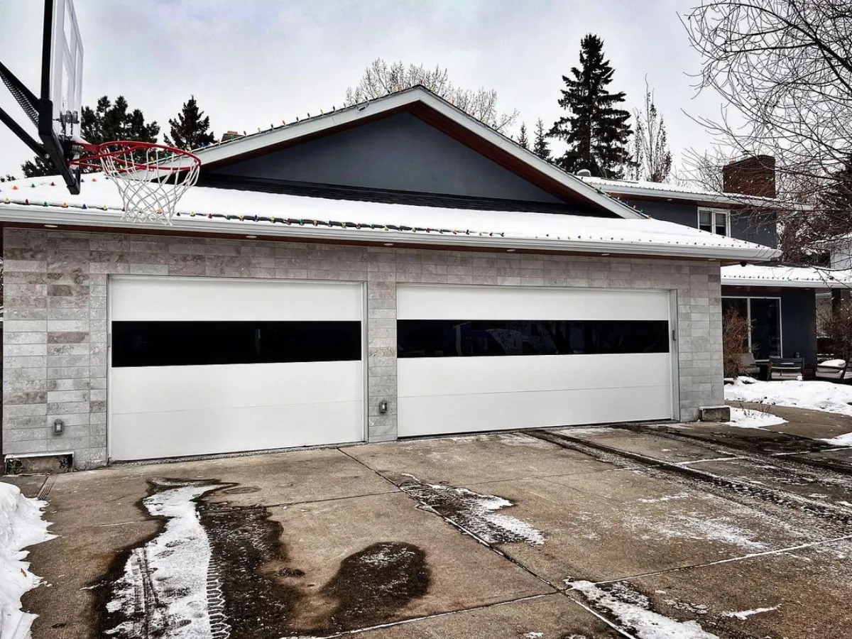 White garage door in a winter setting — Sunriver vacation homes need cold-weather maintenance
